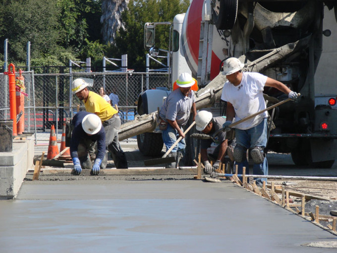 Cement Masons put the finishing touches on a new walkway and plaza at the front of Martin Luther King Jr Middle School in Hayward. 