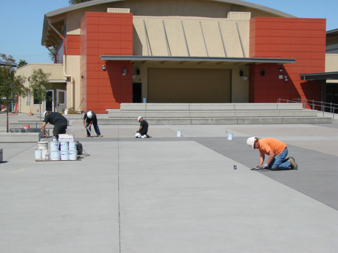 Workers from Hayward-based union contractor Danco Waterproofing complete the caulking of the outdoor plaza area behind the new multi-purpose building.